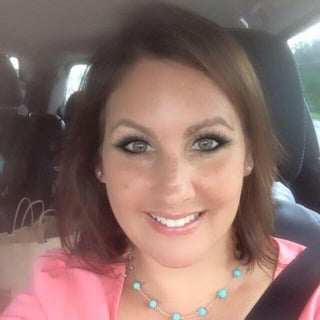 Woman with brown hair and turquoise necklace smiling